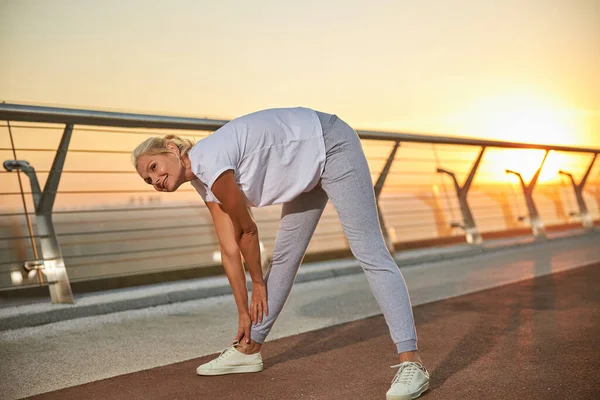 Ausgelassene kaukasische Athletin wärmt sich im Freien auf — Stockfoto