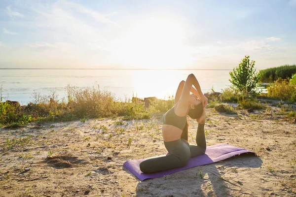 Sporty giovane signora facendo backbend posa yoga nella giornata di sole — Foto Stock
