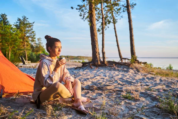 Mooie jonge vrouw die koffie drinkt op het strand — Stockfoto