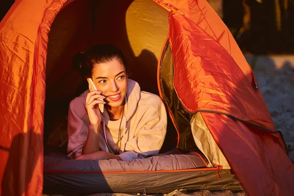 Fröhliche junge Frau telefoniert im Lagerzelt — Stockfoto