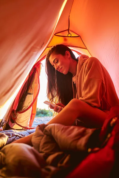 Jubelnde junge Frau mit Handy im Zeltlager — Stockfoto
