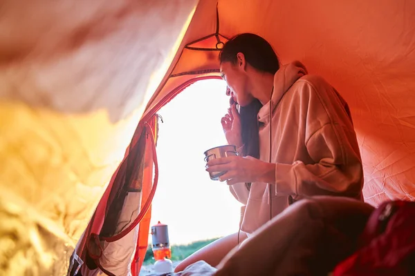 Schöne junge Frau frühstückt im Zeltlager — Stockfoto