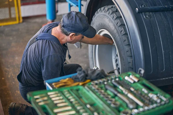 Reparador atento haciendo chequeo de rueda grande —  Fotos de Stock