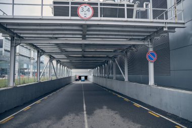 Bagaj traktörü ve araç havaalanında asfalt yolda.