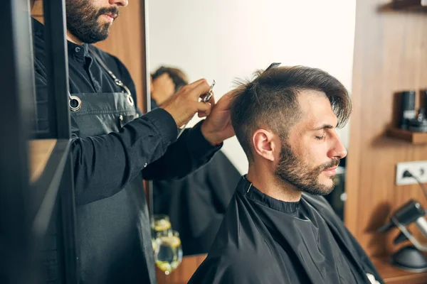 Concentrated master cutting hair of his client — Stock Photo, Image