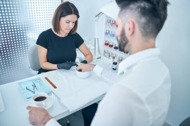 Odaklanmış genç bir kadın tırnak temizliği yapıyor.