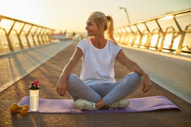 Neşeli kadın sokakta yoga yapıyor.