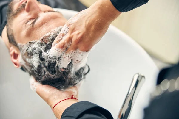 Fotografía enfocada en la mano masculina que lava el cabello —  Fotos de Stock