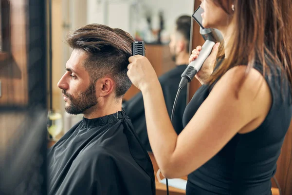 Młoda fryzjerka rozmawia ze swoim przystojnym klientem — Zdjęcie stockowe