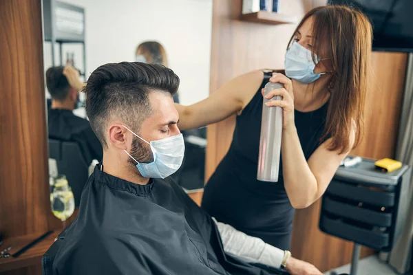 Atento joven peluquero trabajando con un cliente elegante —  Fotos de Stock