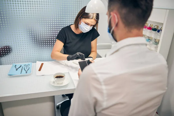 Geconcentreerde brunette vrouw doet haar werk bewust — Stockfoto