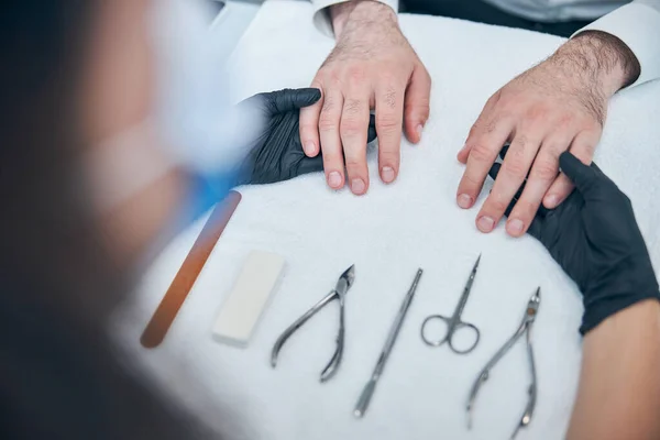 Close up of master examining male hands — Stock Photo, Image