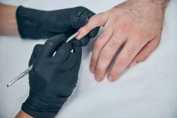 Trabajador profesional usando espátula estéril para manicura —  Fotos de Stock