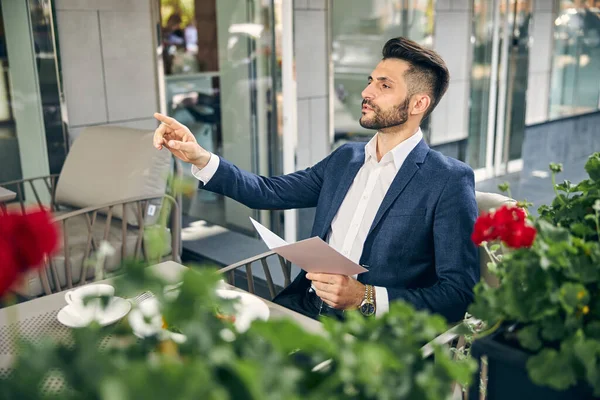 Fešák obchodník hledá číšníka v restauraci — Stock fotografie