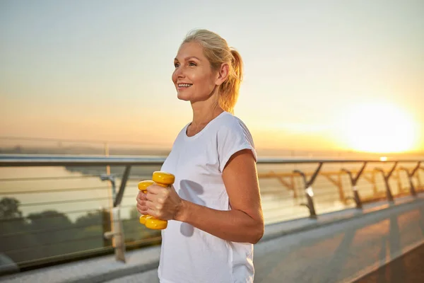 Mujer alegre teniendo entrenamiento matutino en la calle — Foto de Stock