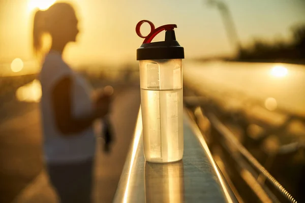 背景がぼやけている女性と水のボトル — ストック写真