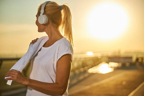 Mujer deportiva escuchando música en la calle — Foto de Stock