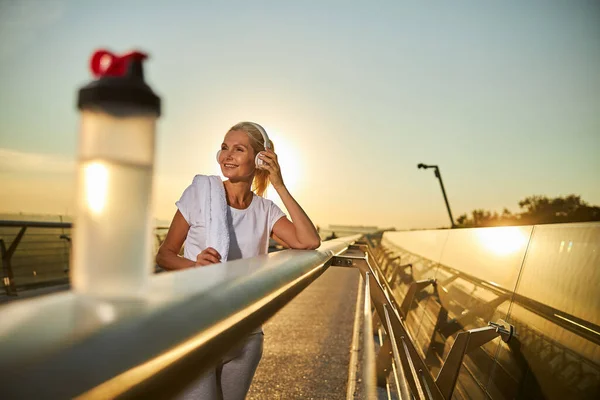 Hermosa mujer alegre escuchando música en la calle — Foto de Stock