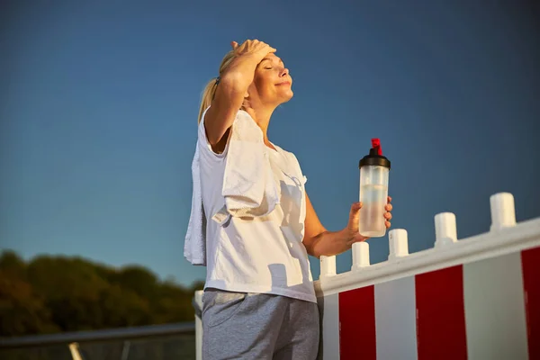 Beautiful sporty woman holding bottle of water — Stock Photo, Image