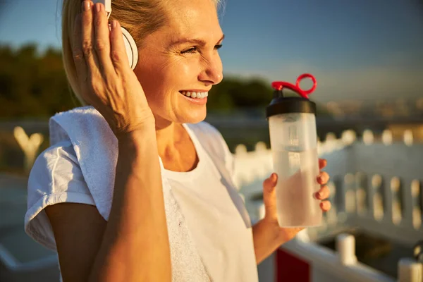 Mujer alegre escuchando música en la calle — Foto de Stock