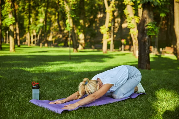 公园里阳光明媚的时候练瑜伽的胖女人 — 图库照片