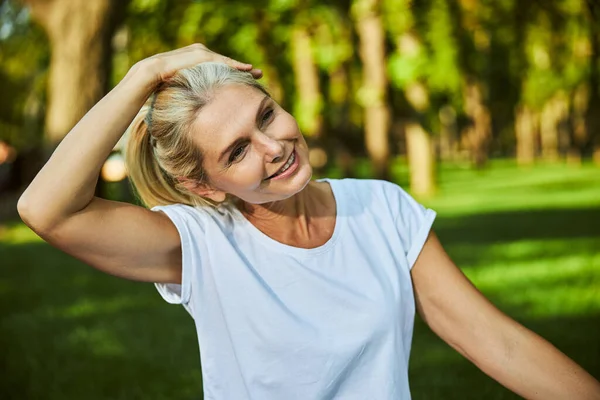Красивая радостная женщина в рубашке проводит время на открытом воздухе — стоковое фото