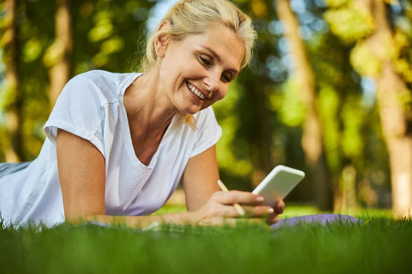 Mooie vrolijke vrouw met behulp van mobiele telefoon op straat — Stockfoto