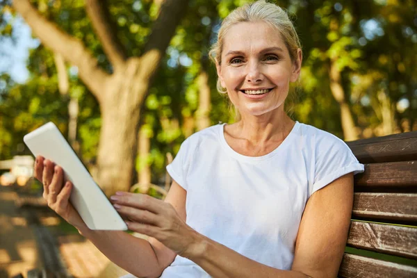 Schöne fröhliche Frau nutzt modernen Tablet-Computer im Freien — Stockfoto