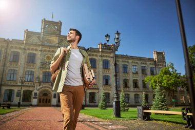 Erkek öğrenci gökyüzüne bakıyor.