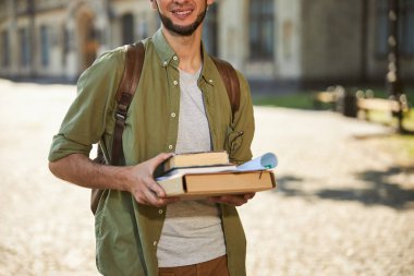 Açık havada gülümseyen bir erkek öğrenci.