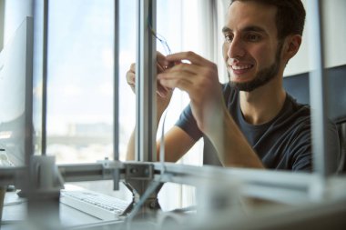 Neşeli genç mühendis laboratuvar ekipmanlarını kontrol ediyor.