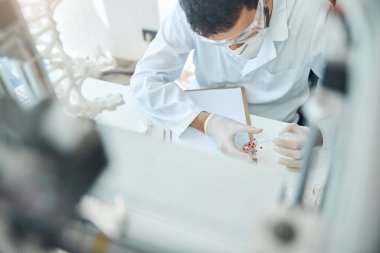 Bir test örneğiyle çalışan erkek bilim adamı.