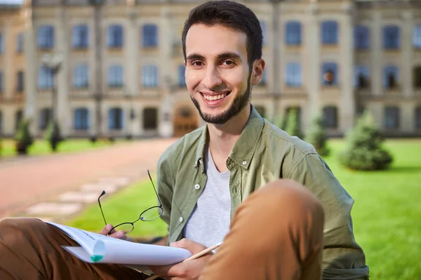 Studerande med flervalssvar sittande utomhus — Stockfoto