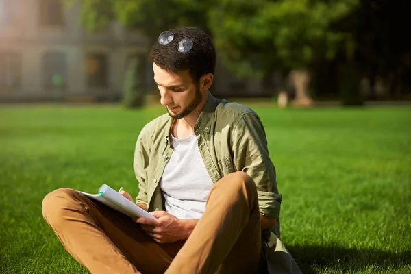 Focalizzato giovane uomo scrivere con una matita — Foto Stock