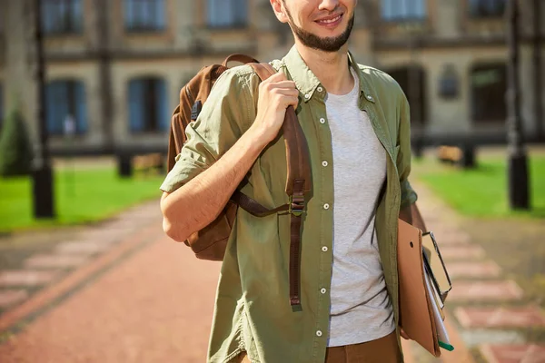 Радостный студент-мужчина с учебниками, стоящими снаружи — стоковое фото