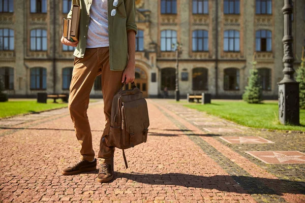 Mann mit einem Stapel Bücher und seinem Rucksack — Stockfoto