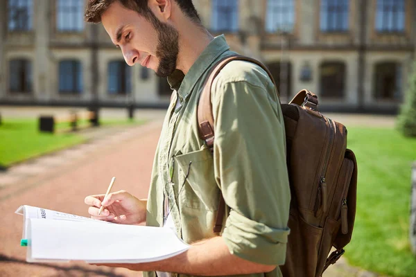 Odaklanmış lisans öğrencisi cevap kağıdını dolduruyor — Stok fotoğraf