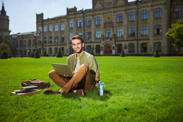 İyi görünümlü, koyu renk saçlı, dizüstü bilgisayarı olan bir üniversite öğrencisi. — Stok fotoğraf