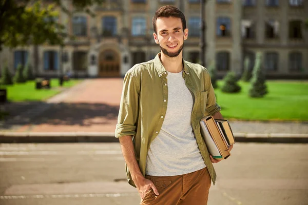 Mignon joyeux moderne masculin de premier cycle tenant des livres — Photo