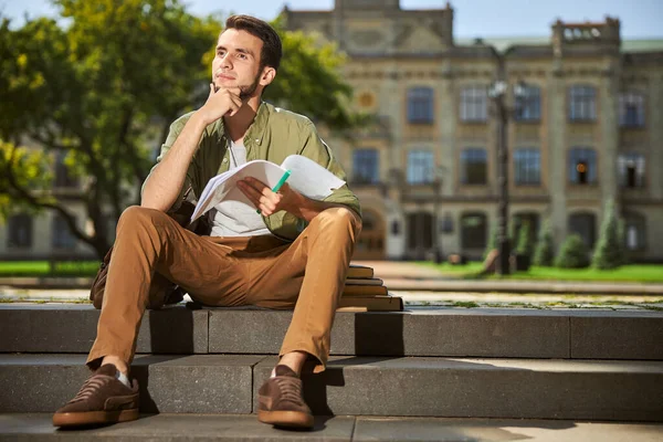Erkek öğrenci ev ödevi üzerinde kafa yoruyor.