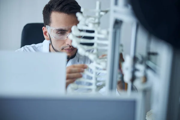 Scienziato maschio guardando il modello a doppia elica — Foto Stock