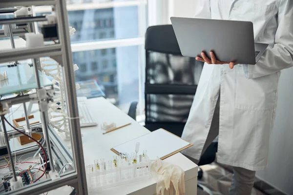 Cientista segurando um laptop em suas mãos — Fotografia de Stock