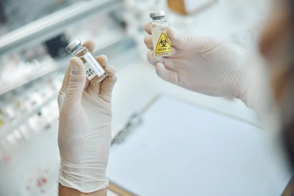 病毒学家用牛皮癣疫苗检查两瓶疫苗 — 图库照片