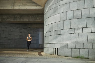 Sabahları yalnız koşan neşeli genç bir kadın.