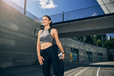 Güzel, aktif esmer kız bacağını esnetiyor.