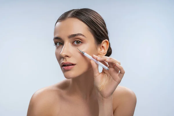 Calma giovane donna utilizzando un dispositivo di rimozione blackhead — Foto Stock