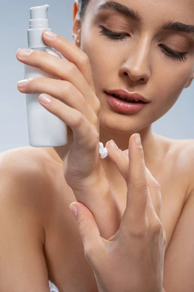 Señora bonita concentrada usando un producto de belleza — Foto de Stock