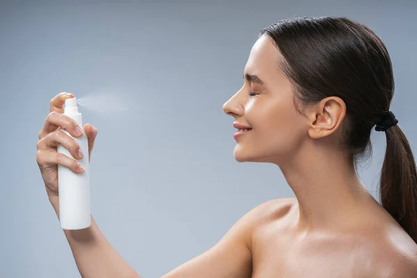 Mujer sonriente con una cola de caballo haciendo un procedimiento de belleza —  Fotos de Stock