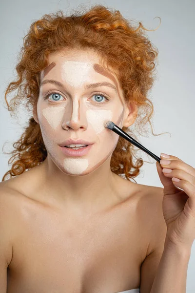 Wanita berambut merah yang menarik menggunakan kuas makeup — Stok Foto