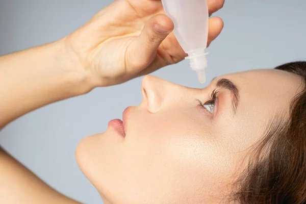 Mujer aplicando un medicamento líquido para los ojos —  Fotos de Stock